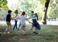 Crianças brincam alegremente ao ar livre em um parque arborizado