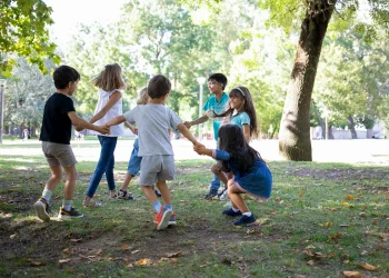 Crianças brincam alegremente ao ar livre em um parque arborizado