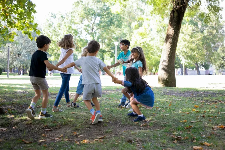 Crianças brincam alegremente ao ar livre em um parque arborizado